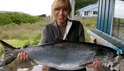 Photo of April White holding a caught salmon.